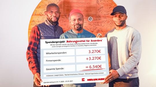 Three colleagues accept the check from Helukabel.