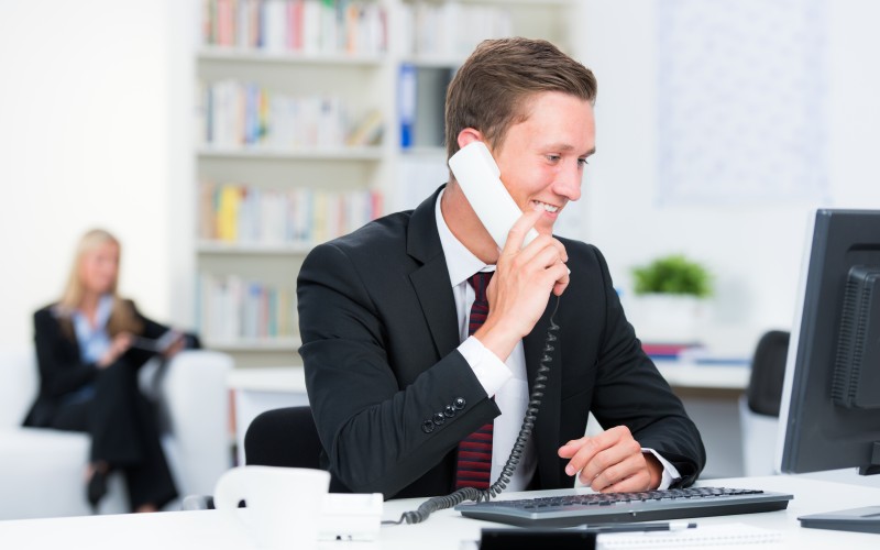 Man sitting at desk and talking on phone