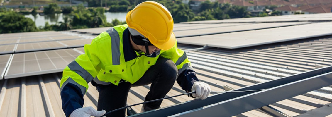 Man working on a photovoltaic system on the roof of a house