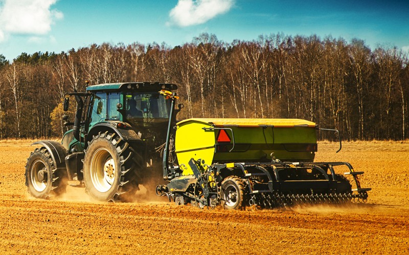 Traktor auf einem landwirtschaftlichen Feld im Frühjahr