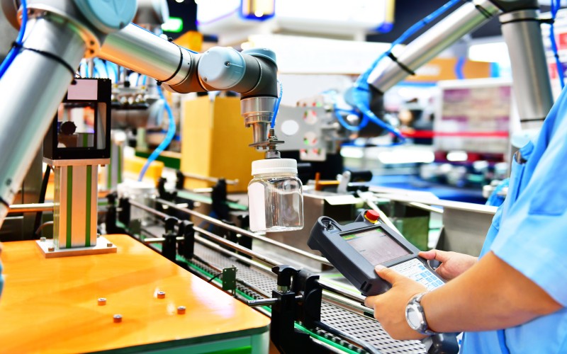 Engineer checks and controls automation robot arms