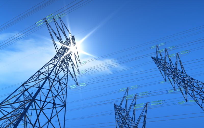 Transmission tower with blue sky and sun