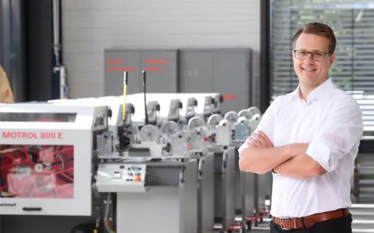 Schwindhammer standing in front of a cable winding machine
