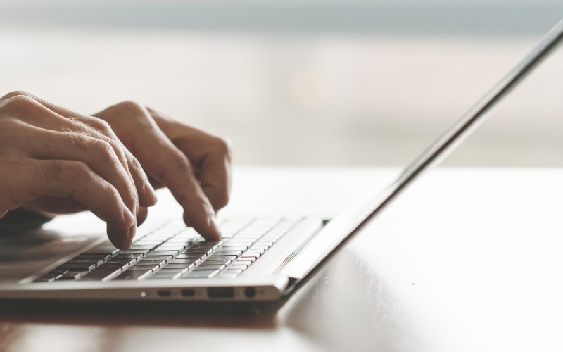 Hands writing on a laptop