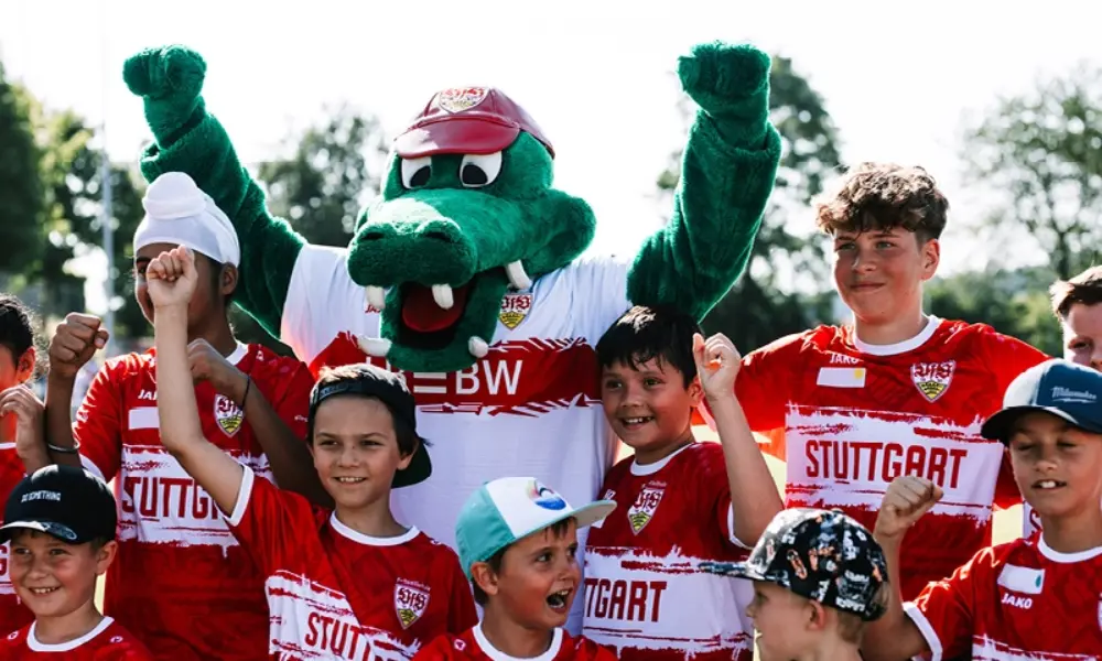 Childen taking a photo with VfB mascot Fritzle