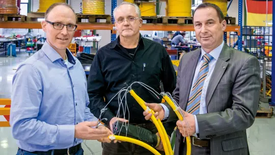 Kai Berger, Michael Nees and Albrecht Bathon hold a cable