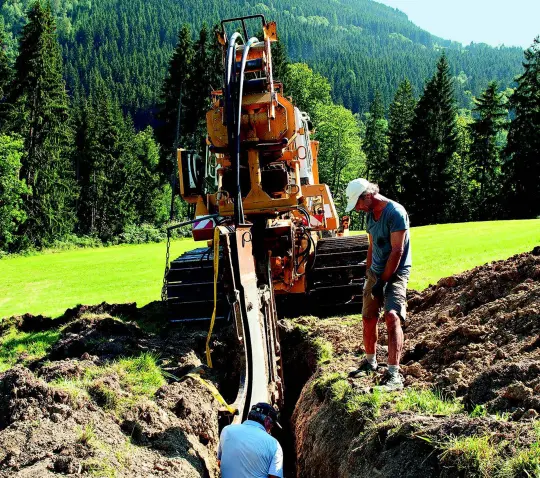 Graafmachine legt kabel in de natuur Graafmachine legt kabel in de natuur