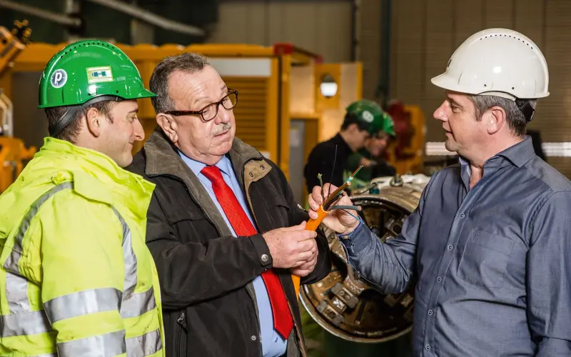 three men look at the cables of the E-Power Pipe