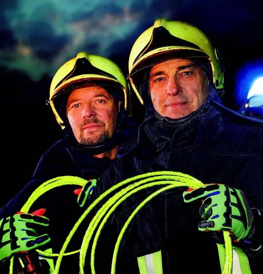 twee brandweermannen houden de helupower in de camera reflecterend