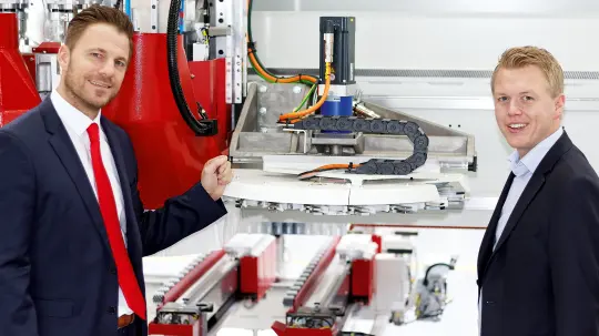 Spranger and Sulewski look at a machine Spranger and Sulewski look at a machine
