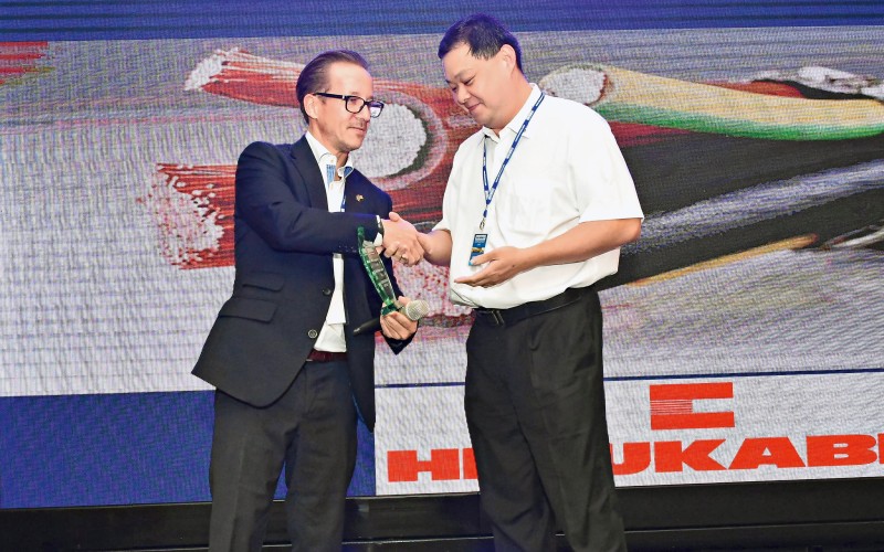 A man giving another man a trophy