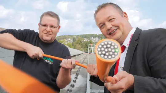 Holger Groos und Henning Hambloch schauen die orangen Kabel an