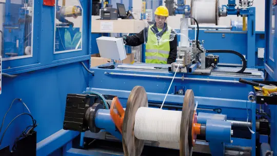 Employee operates cable cutting machine