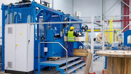 Employee operates cable cutting machine