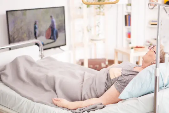 Person lying in bed in hospital room